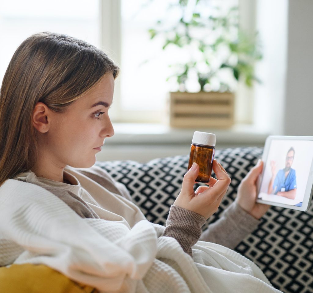 young woman having video call with doctor on tablet at home online consultation concept