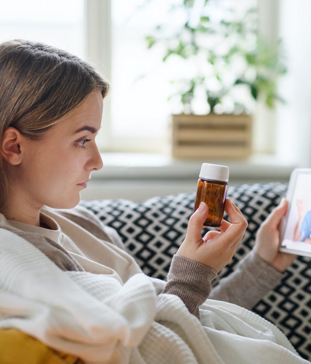 young woman having video call with doctor on tablet at home online consultation concept
